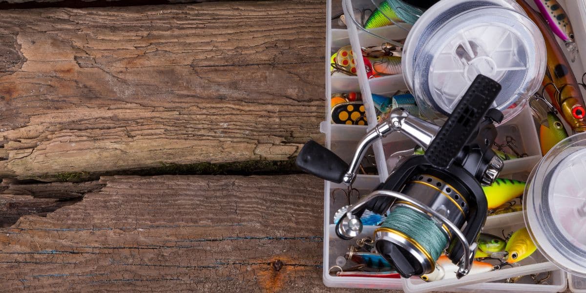 A fishing reel resting on an open tackle box