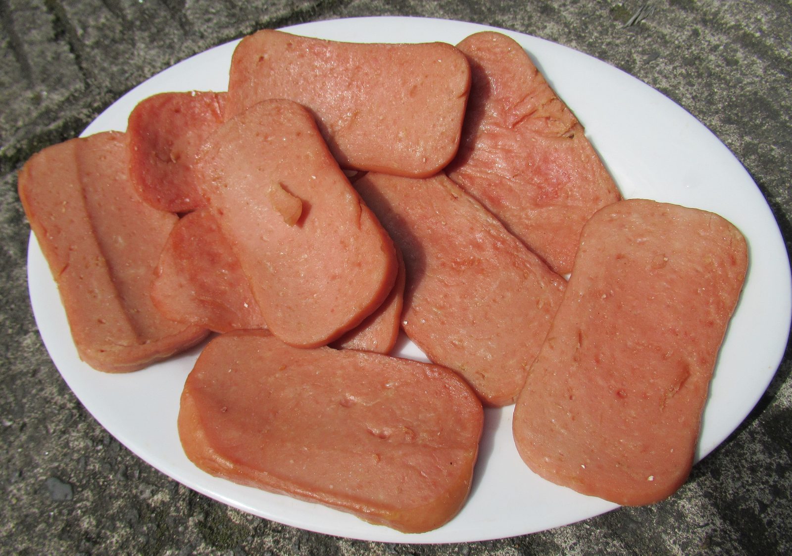 Slices of luncheon meat on a white plate
