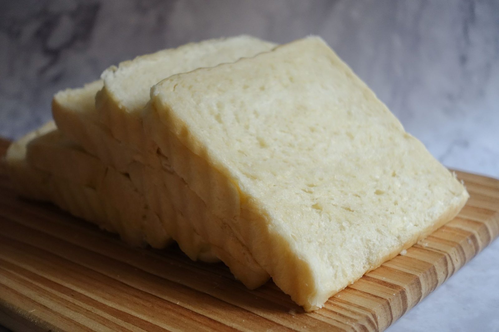 A sliced white loaf on a wooden board